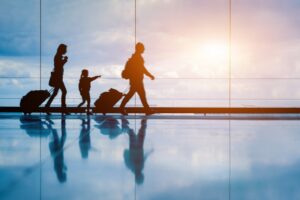 family walking in an airport with their luggage