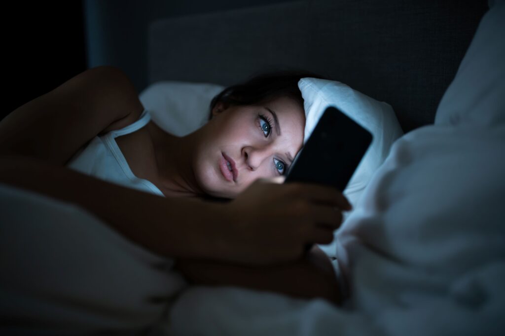 Woman on her smartphone in bed